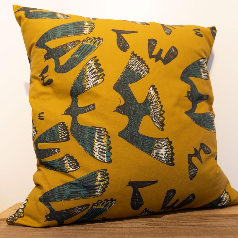 photo of cushion with lapwing design on mustard background